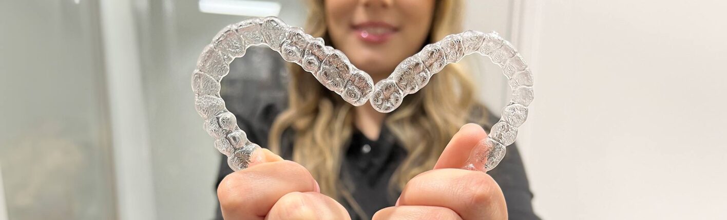 Invisalign clear aligners held in a heart shape